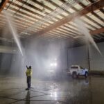 worker spraying water in the roof